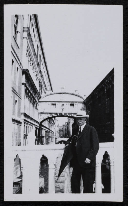 Black and white photograph of Charles Chesnutt in front of a bridge in Venice during his 1912 trip to Europe.